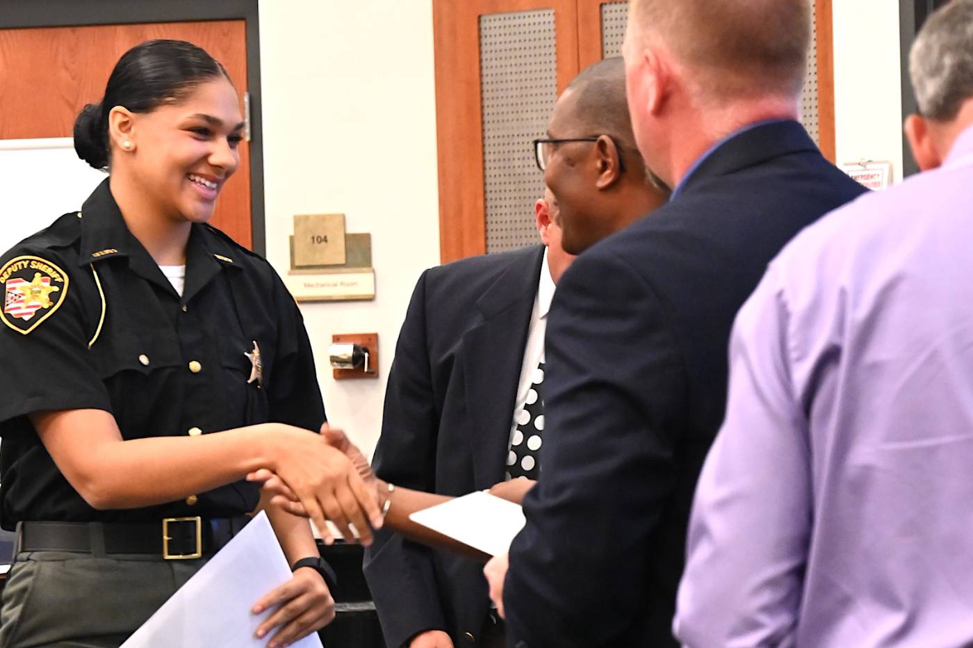 Female officer shaking hands at recognition ceremony
