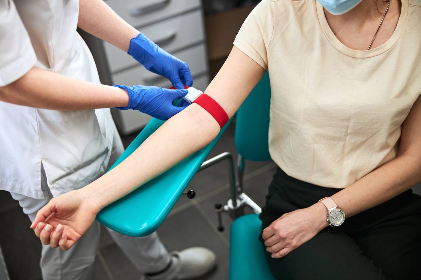 Medical lab assistant preparing to draw blood from patient