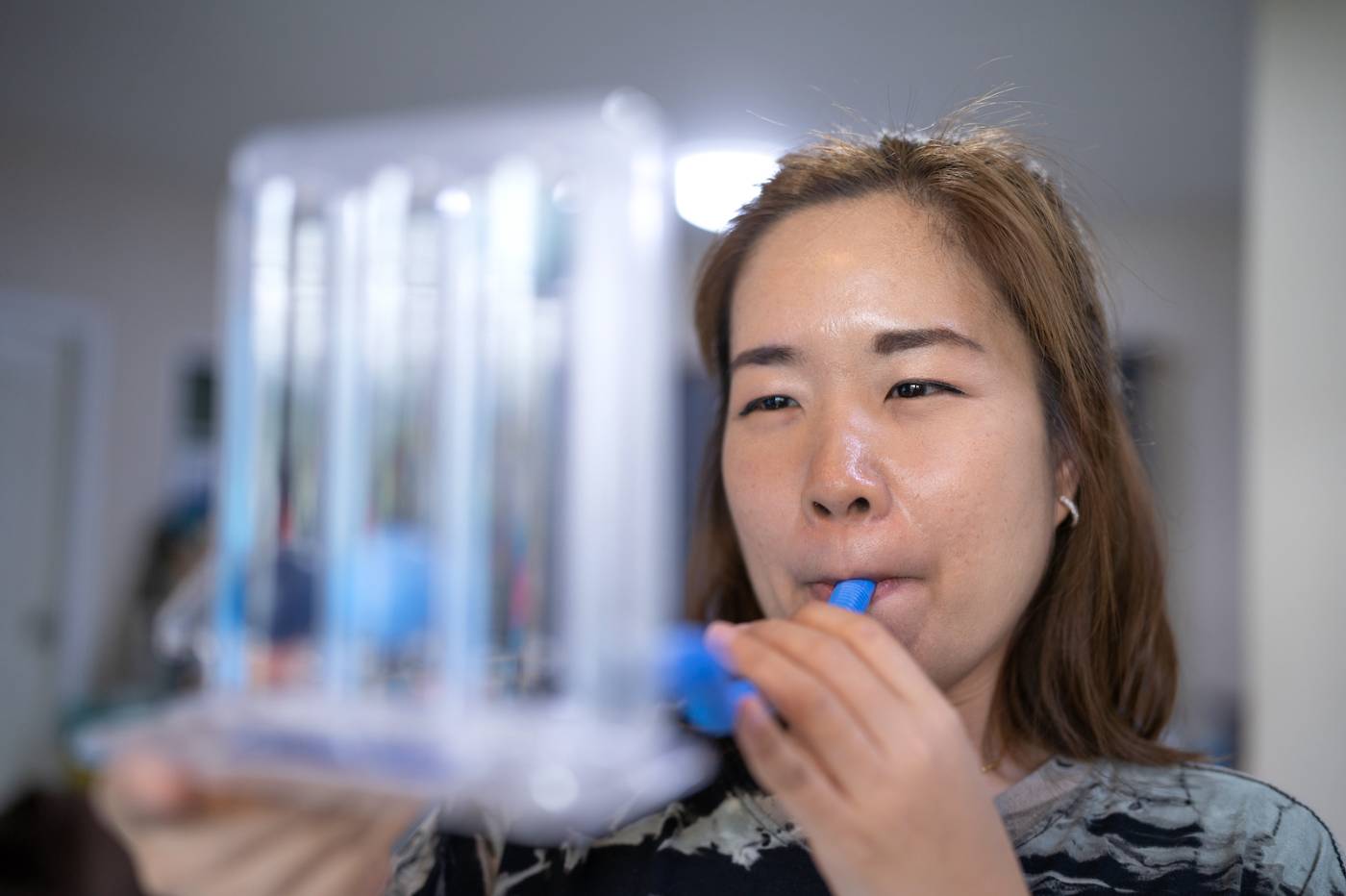 Asian female student demonstrates the use of a breathing device
